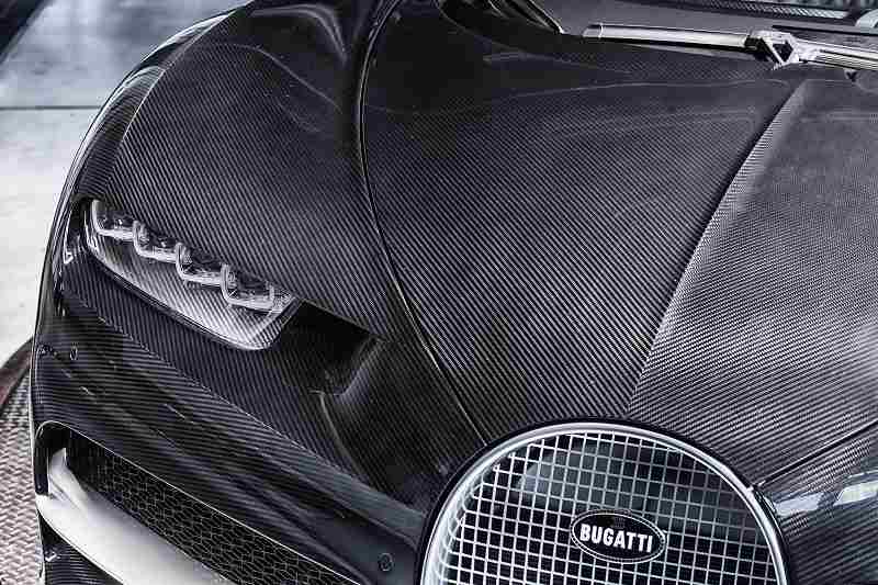 <p>エレガンス仕様はシャイニーカーボンファイバーボディを採用。純銀製のブガッティエンブレムにブラックエナメルを施し、漆黒の美しさを際立たせる。</p>