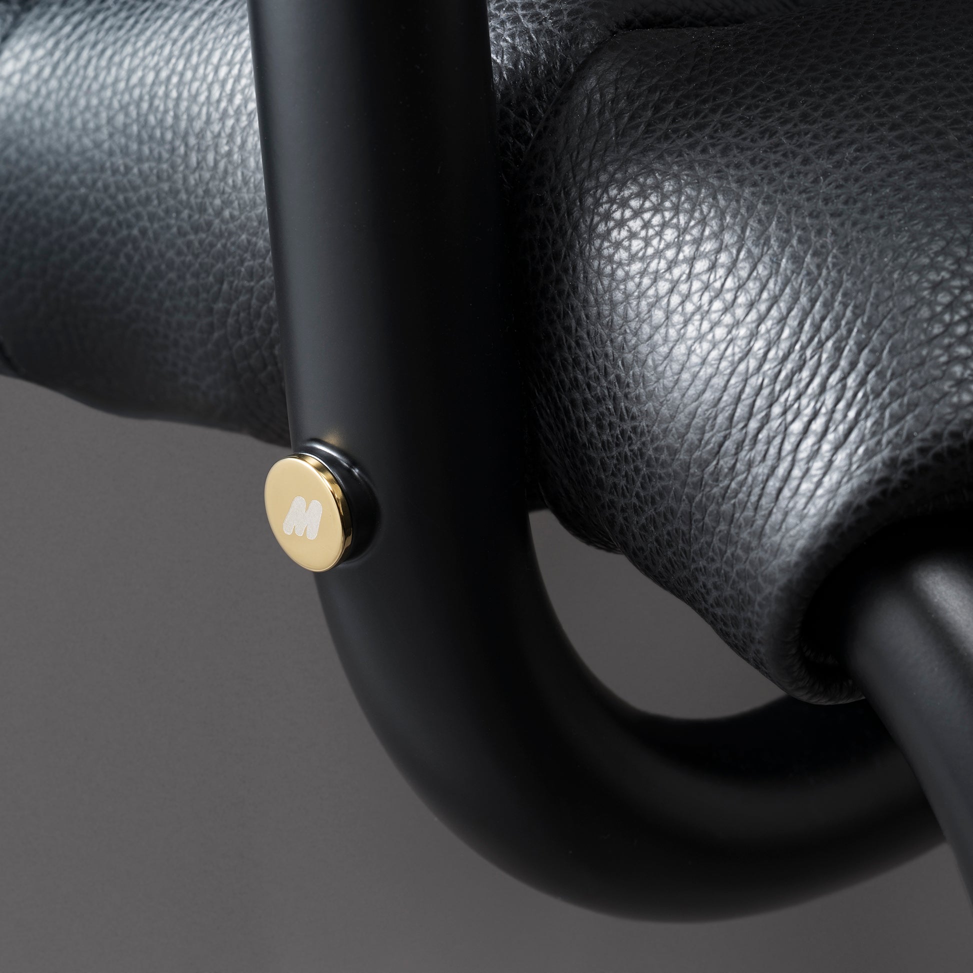 <p>オーバーサイズの黒色メタルフレームを採用し、真鍮製“M”ロゴキャップと手縫いレザーヘムが特徴。シートカバーは調整・交換が可能でメンテナンス性も高い。</p>